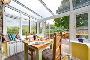 a conservatory with a table and chairs and windows at 2 Bed in Arkengarthdale oc-ds951 in Richmond
