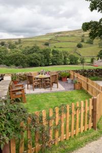 a garden with a wooden fence and a table and chairs at 2 Bed in Arkengarthdale oc-ds951 in Richmond