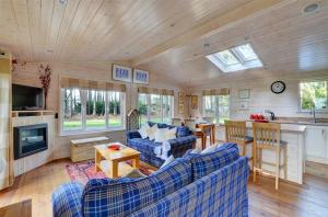 a living room with blue couches and a kitchen at 2 Bed in Weybourne oc-1628 in Kelling
