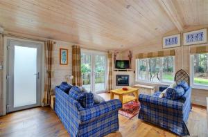 a living room with two blue chairs and a table at 2 Bed in Weybourne oc-1628 in Kelling