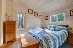 a bedroom with a bed in a wooden cabin at 2 Bed in Weybourne oc-1628 in Kelling
