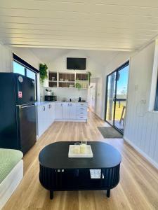 a kitchen with a black refrigerator and a table at El Rancho Cabarita Beach - Highlander in Clothiers Creek