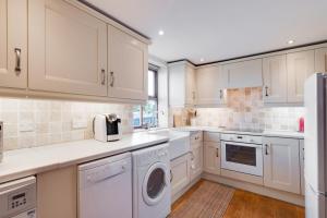 a kitchen with white cabinets and a washer and dryer at 2 Bed in Chatton oc-nb620 in Chatton