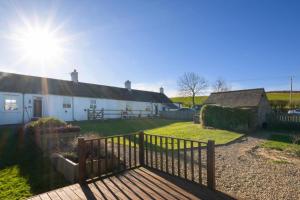 a white house with a wooden fence in front of it at 2 Bed in Chatton oc-nb620 in Chatton