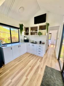 a kitchen with white cabinets and a flat screen tv at El Rancho Cabarita Beach - Highlander in Clothiers Creek +28 photos
