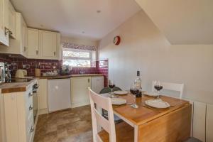 a kitchen with a table with two glasses of wine at 2 Bed in Gayle oc-ds912 in Hawes +14 photos