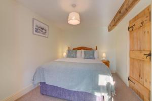 a bedroom with a bed and a wooden door at 2 Bed in Gayle oc-ds912 in Hawes