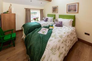 zwei Betten in einem Zimmer mit grünem Kopfteil in der Unterkunft 2 Bed in High Fremington oc-ds375 in Reeth