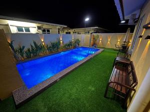 a swimming pool in the middle of a yard at night at Paradise Homestay Marang in Marang