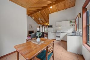 a kitchen with a wooden table with a vase on it at Mountainside Villa One in Halls Gap