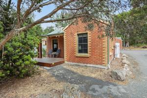 a brick house with a porch and a deck at Mountainside Villa One in Halls Gap