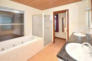 a bathroom with two sinks and a bath tub at Mountainside Villa One in Halls Gap +18 photos