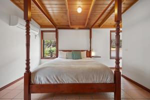 a bed in a room with a wooden ceiling at Mountainside Villa One in Halls Gap