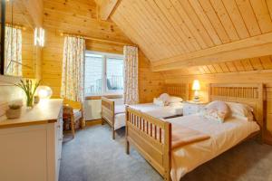 a bedroom with two beds in a log cabin at 4 Bed in Wadebridge oc-p00066 in Little Petherick