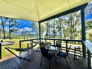 a porch with a hammock and a table and chairs at El Rancho Cabarita Beach - Highlander in Clothiers Creek