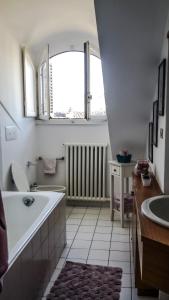 a bathroom with a tub and a sink and a window at Anduma Bin in Turin