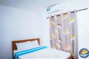 a bedroom with a bed and a curtain at Ceylon Retreat Villa in Kamburugamuwa