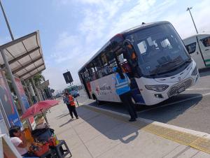 a person standing next to a bus at a bus stop at Hospedaje Dajoka's in Lima