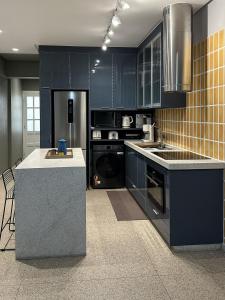 a kitchen with blue cabinets and a counter top at Guarapari Center Aparts in Guarapari
