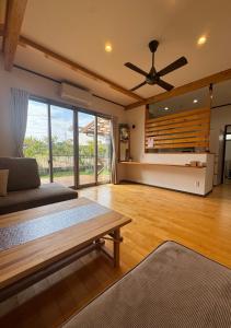 a living room with a couch and a ceiling fan at SerenityBlueAmami in Tatsugo