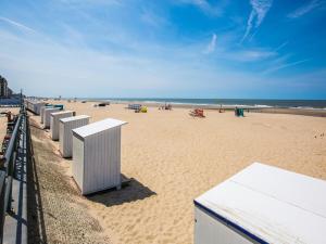 a beach with a row of white boxes on it at Apartment with Pool and Sea View in Middelkerke