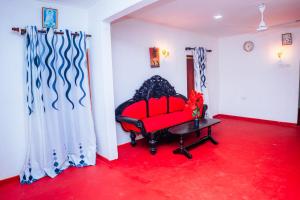 a red couch in a room with a red carpet at Ceylon Retreat Villa in Kamburugamuwa