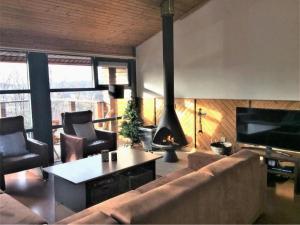 a living room with a couch and a fire place at Chalet in Odeigne with Private Pool & Sauna in Manhay