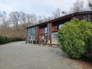 a house with glass windows and a bush at Chalet in Odeigne with Private Pool & Sauna in Manhay