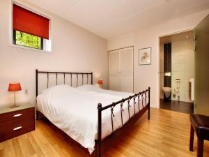 a bedroom with a large bed and a bathroom at Chalet in Odeigne with Private Pool & Sauna in Manhay +28 photos