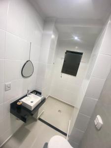 a white bathroom with a sink and a toilet at Seja Bem-Vindos, sinta-se em Casa ! in São Lourenço