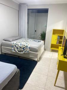 a bedroom with two beds and a yellow cabinet at Seja Bem-Vindos, sinta-se em Casa ! in São Lourenço