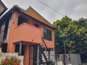 a orange house with a staircase in front of it at Forge boutique in Chiang Mai