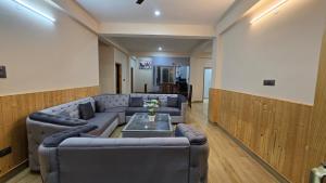 a living room with a couch and a table at Aashvika Homes in Katrain