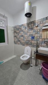 a bathroom with a toilet and a sink at Aashvika Homes in Katrain +11 photos