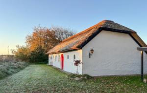 a small white building with a thatched roof at Amazing Home In Ulfborg With Kitchen in Ulfborg +17 photos