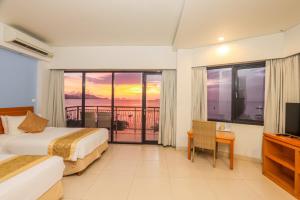 a hotel room with two beds and a television at Laprima Hotel in Labuan Bajo