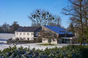 a large white house with a black roof at Hôtel le Corbusson Laval Ouest in Saint-Berthevin-sur-Vicoin
