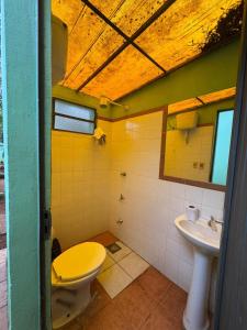ein Badezimmer mit gelber Toilette und Waschbecken in der Unterkunft Casa quinta en Capiatá in Capiatá