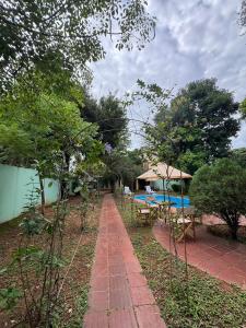 Ein gepflasterter Gehweg mit Tisch und Stühlen im Garten in der Unterkunft Casa quinta en Capiatá in Capiatá