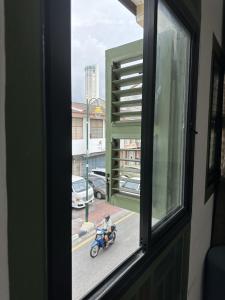 a person riding a motorcycle through a window at Aceh Suites by Aayu - 1 min walk to Armenian St in George Town