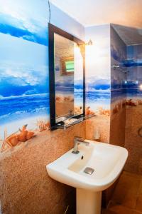 a bathroom with a sink and a painting on the wall at Ceylon Retreat Villa in Kamburugamuwa
