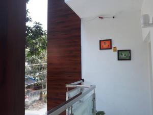 a view from the balcony of a house with two pictures on the wall at Orchid Woods in Trivandrum