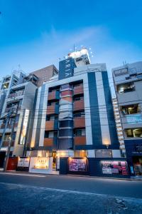 a building on a city street with tall buildings at HOTEL ARIA-Yokohama Kannai in Yokohama