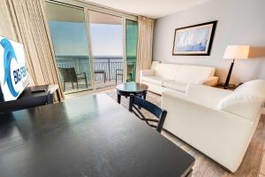 a living room with a couch and a table at Romantic Honey Moon Suite, Direct Oceanfront,Pools in Myrtle Beach