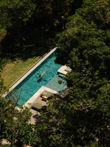 an overhead view of a swimming pool with a person in the water at Vila Figo in Trancoso