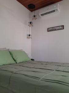 a bedroom with a bed with green sheets and lights at Perfect Getaway #1 in La Libertad