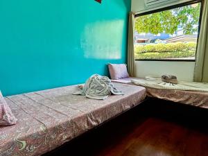 a room with two beds and a window at Ngermid Oasis - Vibrant 2 BD/1 BA Duplex in Ngermid +37 photos