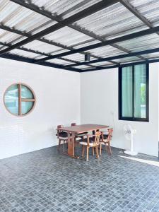 a dining room with a wooden table and chairs at Sea & Sand House in Ban Khlong Khut