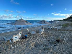 a group of chairs and umbrellas on a beach at Beach Class Verano 01 A in Ipojuca
