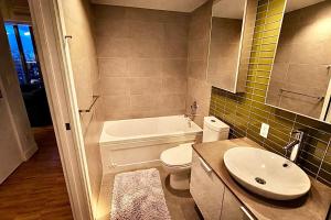 a bathroom with a white toilet and a sink at Pacific Pearl in Vancouver